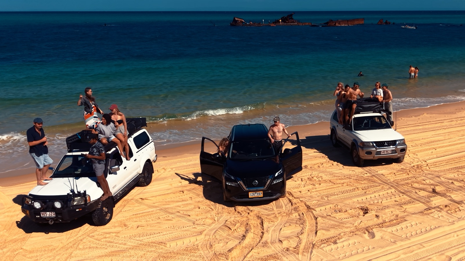 Campfire Crew vehicles and travellers beside the Tangalooma Wrecks