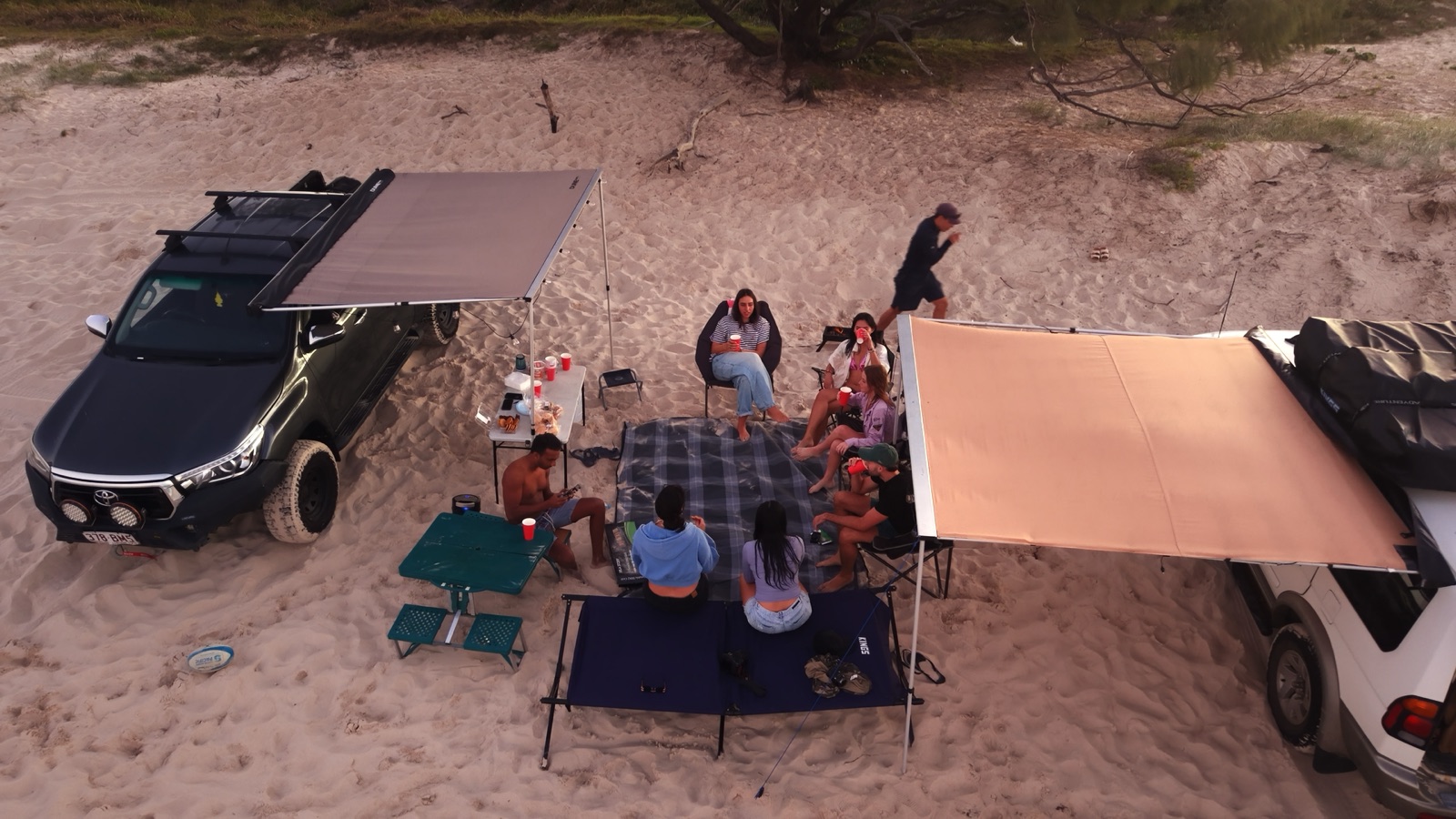 Campfire Crew travellers gathered at their shared Moreton Island campsite