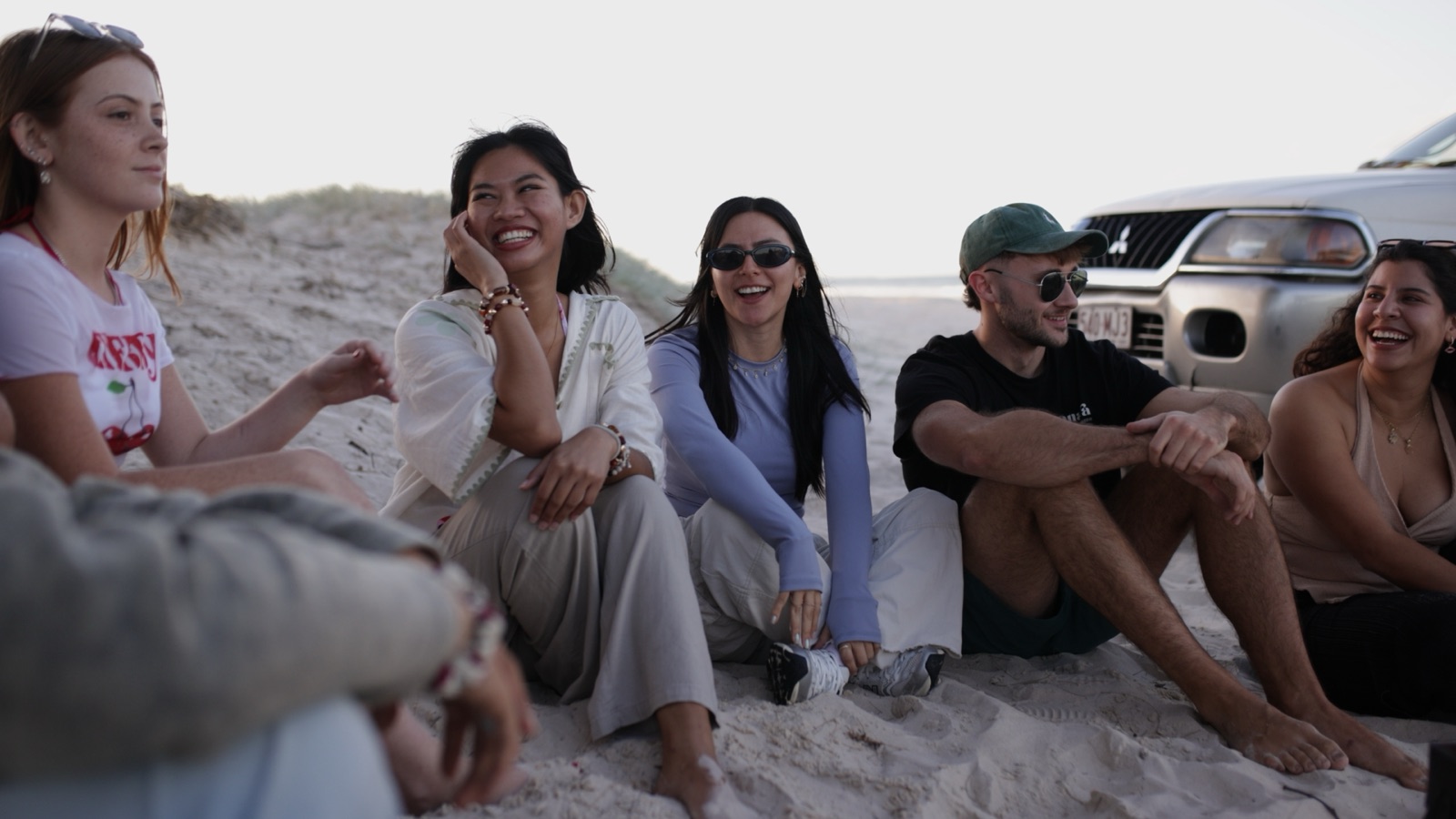 Friends relaxing together at sunset on Moreton Island
