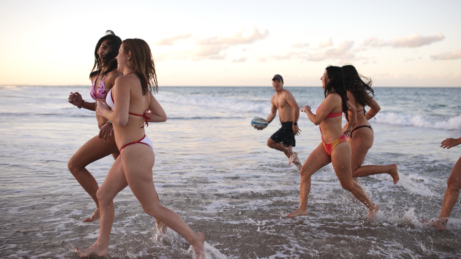 Campfire Crew travellers running into the ocean