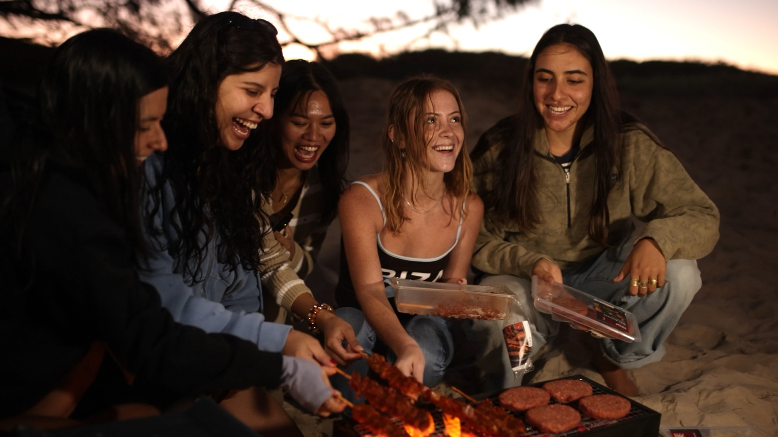 Travellers sharing dinner during a Moreton Island camping tour
